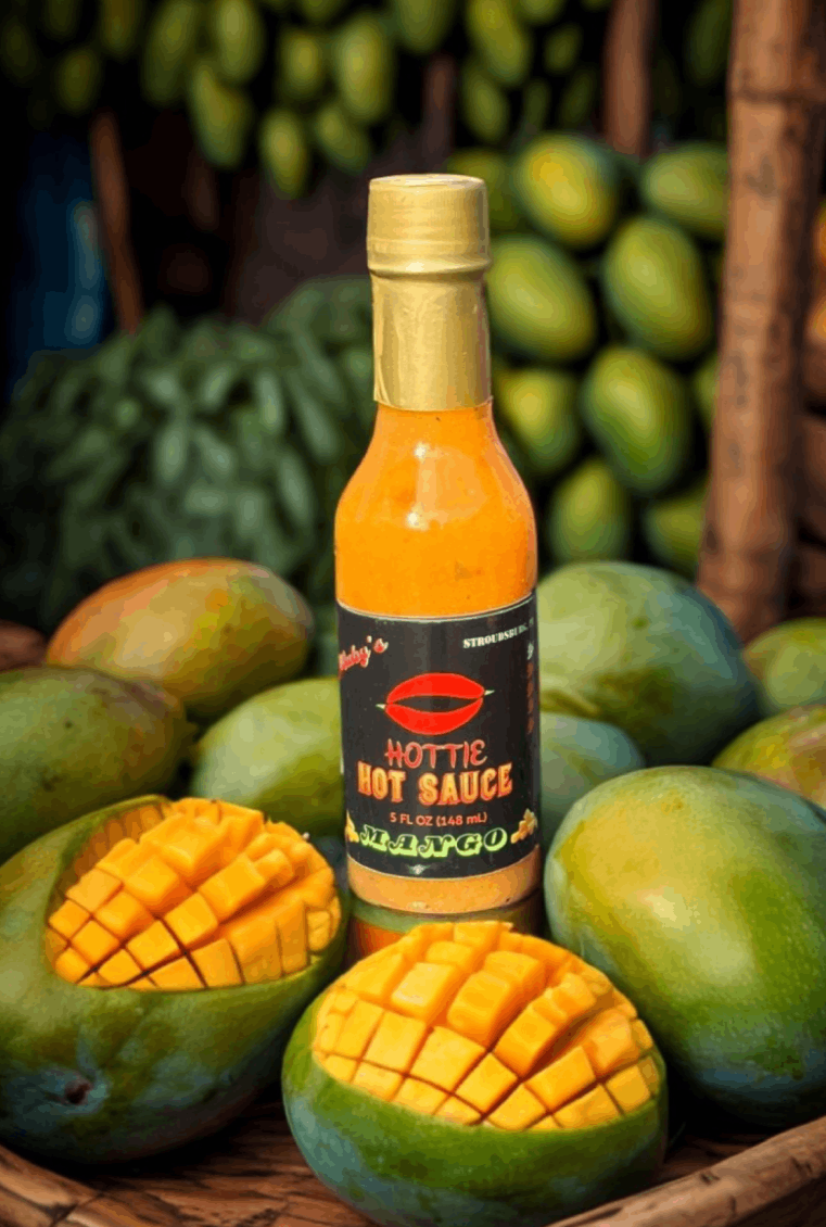 A bottle of hot sauce sitting on top of some mangos.